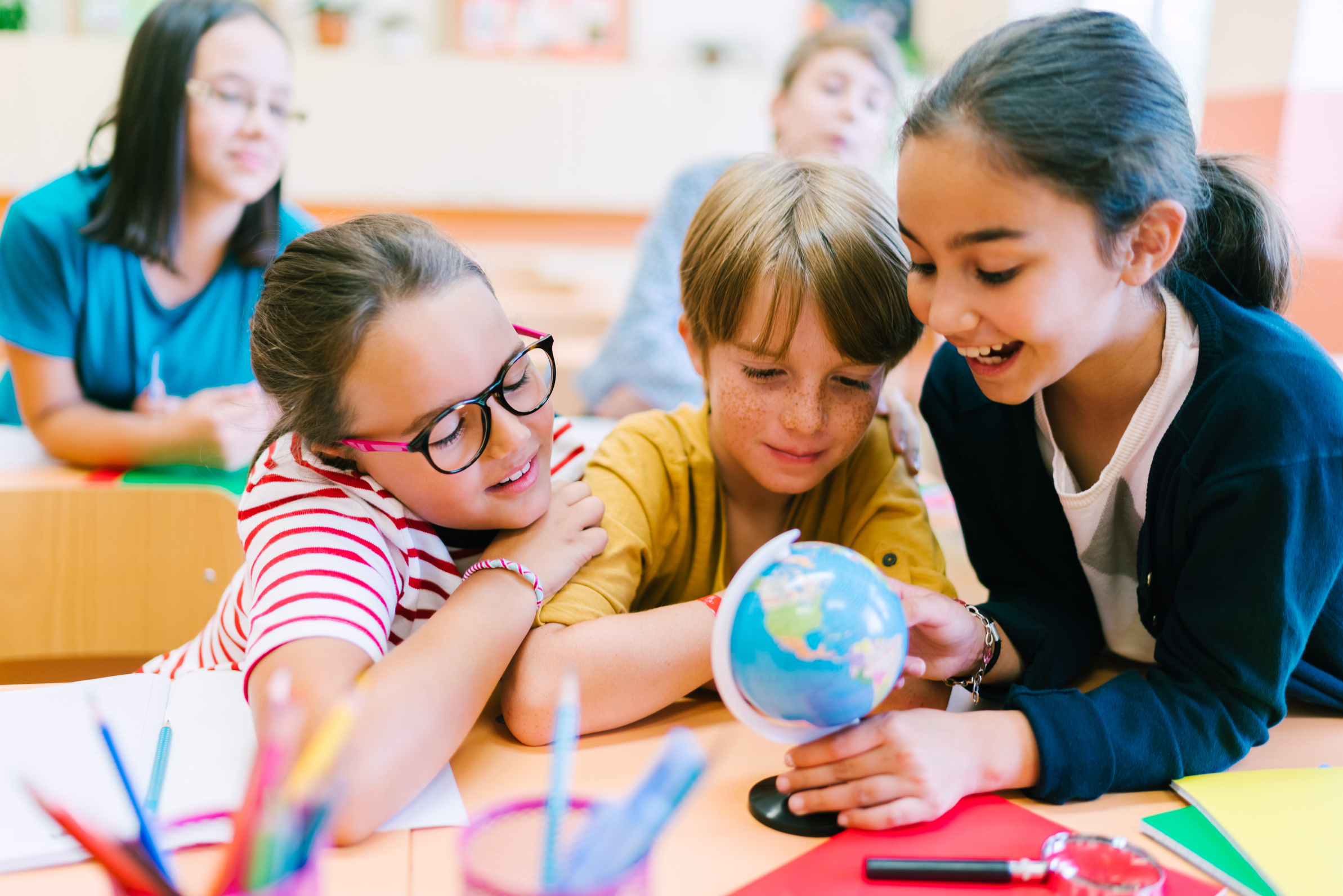 School children studying geography on globe